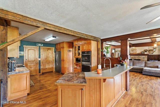 3297 Minaloosa Valley Rd, Plummer, ID 83851 - kitchen featuring appliances with stainless steel finishes, light wood-type flooring, a textured ceiling, open floor plan, and ceiling fan