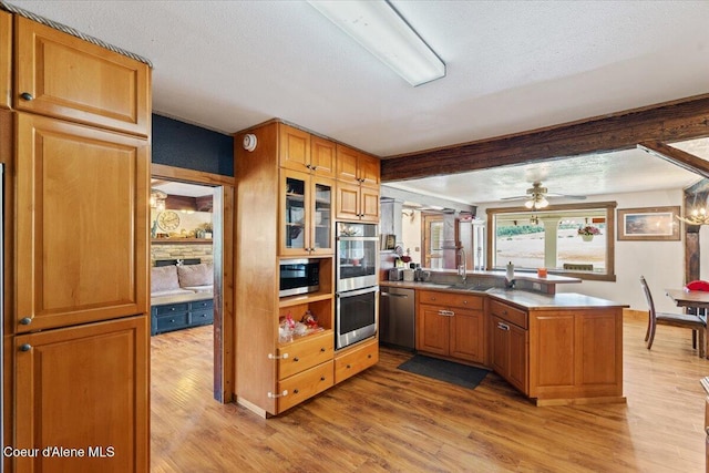 3297 Minaloosa Valley Rd, Plummer, ID 83851 - kitchen featuring stainless steel appliances, a peninsula, light wood finished floors, glass insert cabinets, and beamed ceiling
