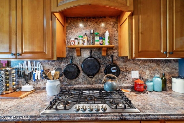 3297 Minaloosa Valley Rd, Plummer, ID 83851 - kitchen featuring stainless steel gas stovetop, tasteful backsplash, arched walkways, and brown cabinetry