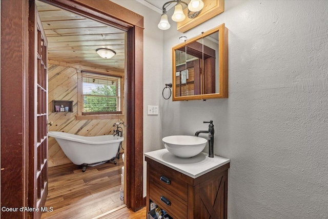3297 Minaloosa Valley Rd, Plummer, ID 83851 - full bathroom featuring vanity, a freestanding bath, wood-type flooring, a textured wall, and wooden walls