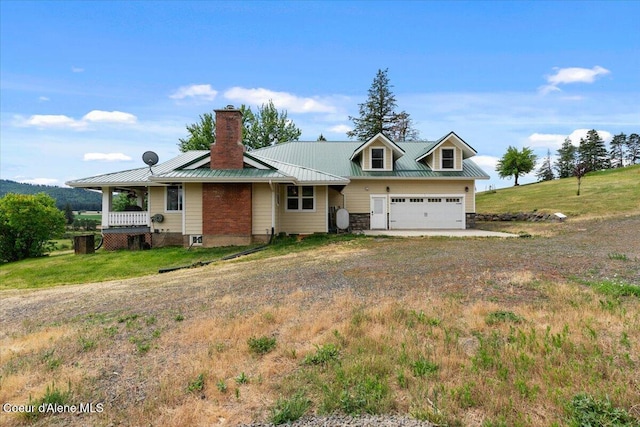 3297 Minaloosa Valley Rd, Plummer, ID 83851 - view of front of home with a chimney, driveway, a metal roof, a garage, and a standing seam roof