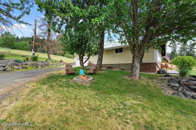 3297 Minaloosa Valley Rd, Plummer, ID 83851 - view of grassy yard featuring an outdoor fire pit and a garage