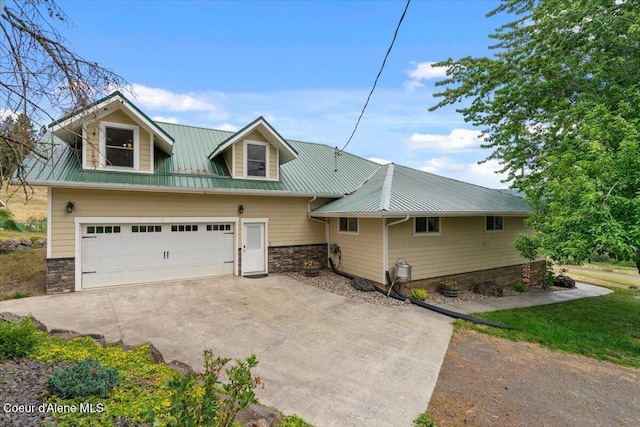 3297 Minaloosa Valley Rd, Plummer, ID 83851 - view of front of home with concrete driveway, stone siding, a metal roof, and an attached garage