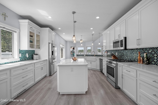 9433 N Justice Way, Hayden, ID 83835 - kitchen featuring appliances with stainless steel finishes, healthy amount of natural light, white cabinets, decorative backsplash, and recessed lighting