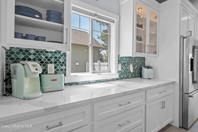 9433 N Justice Way, Hayden, ID 83835 - kitchen featuring stainless steel fridge with ice dispenser, white cabinets, glass insert cabinets, tasteful backsplash, and light stone counters