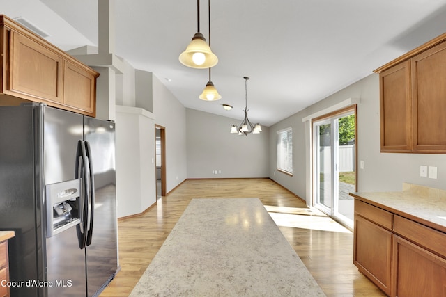 13388 N Polaris St, Rathdrum, ID 83858 - kitchen featuring refrigerator with ice dispenser, vaulted ceiling, a chandelier, light wood-type flooring, and pendant lighting