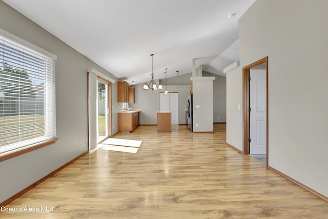 13388 N Polaris St, Rathdrum, ID 83858 - unfurnished living room featuring a chandelier, light wood finished floors, and vaulted ceiling