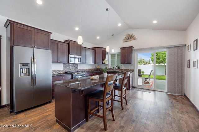 10939 N Seaside St, Hayden, ID 83835 - kitchen with appliances with stainless steel finishes, dark brown cabinets, a breakfast bar, a center island, and dark stone counters