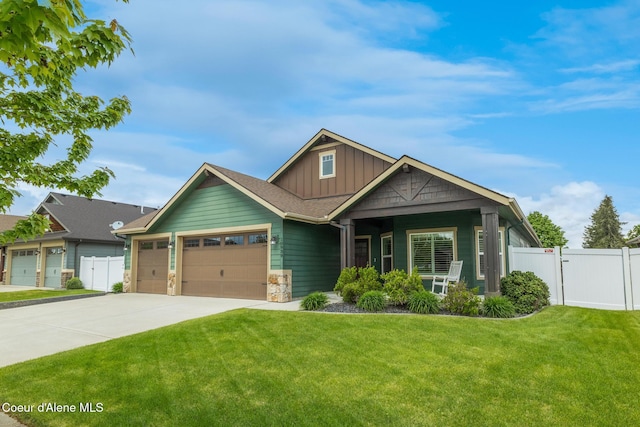 10939 N Seaside St, Hayden, ID 83835 - craftsman inspired home with board and batten siding, an attached garage, driveway, a gate, and stone siding