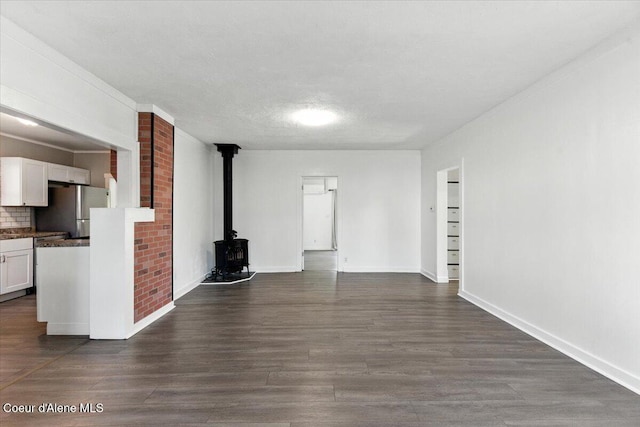 1613 E Coeur D Alene Ave, Coeur Dalene, ID 83814 - unfurnished living room featuring a wood stove and dark wood-type flooring
