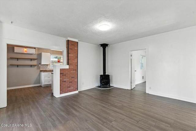 1613 E Coeur D Alene Ave, Coeur Dalene, ID 83814 - unfurnished living room featuring a wood stove, dark wood-style flooring, a textured ceiling, and a wall mounted air conditioner