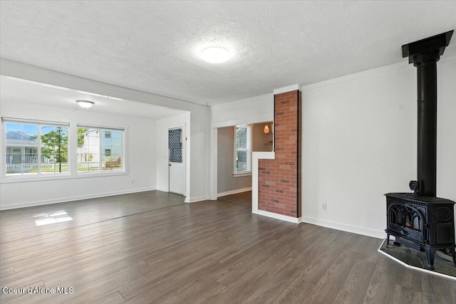 1613 E Coeur D Alene Ave, Coeur Dalene, ID 83814 - unfurnished living room featuring a textured ceiling, dark wood-style floors, a wood stove, and healthy amount of natural light