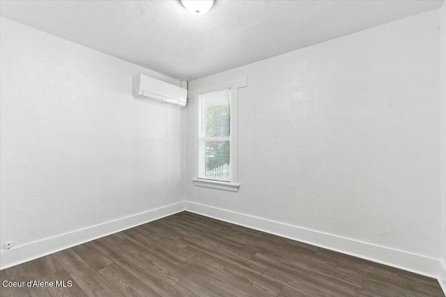 1613 E Coeur D Alene Ave, Coeur Dalene, ID 83814 - unfurnished room with a wall mounted air conditioner and dark wood finished floors