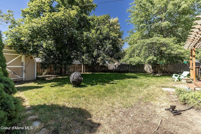 1814 E Jenny Lynn Ln, Coeur Dalene, ID 83815 - fenced backyard featuring an outdoor fire pit and a storage unit
