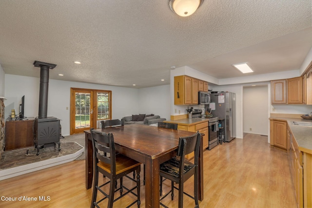1814 E Jenny Lynn Ln, Coeur Dalene, ID 83815 - dining space with a wood stove, light wood finished floors, a textured ceiling, and recessed lighting