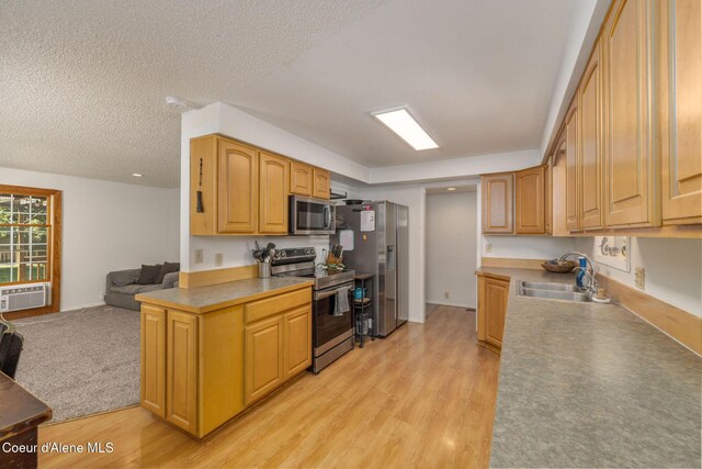 1814 E Jenny Lynn Ln, Coeur Dalene, ID 83815 - kitchen with stainless steel appliances, light wood-type flooring, open floor plan, light countertops, and a textured ceiling