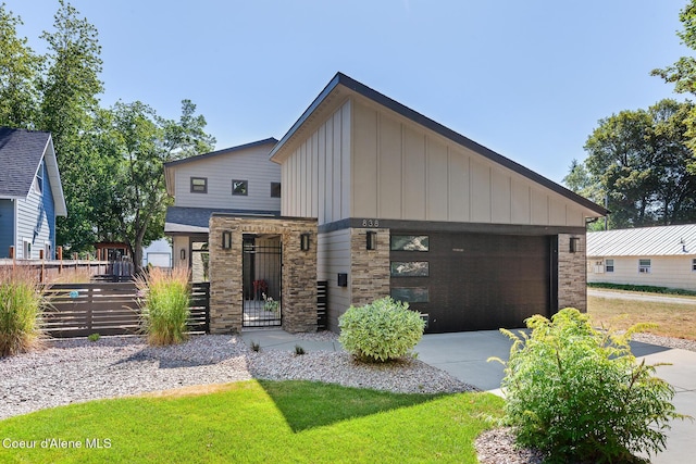 838 N Government Way, Coeur Dalene, ID 83814 - contemporary house with board and batten siding, concrete driveway, an attached garage, and stone siding