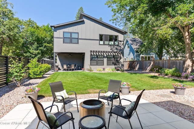 838 N Government Way, Coeur Dalene, ID 83814 - back of property with a fire pit, board and batten siding, a patio, ceiling fan, and a fenced backyard
