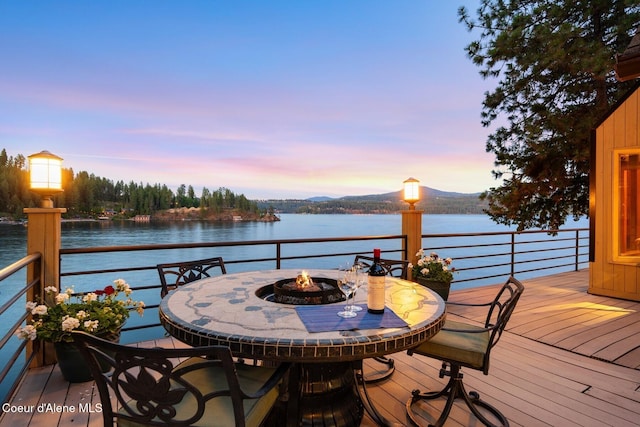 1750 W Valhalla Rd, Coeur Dalene, ID 83814 - deck at dusk with an outdoor fire pit, a water view, and outdoor dining space