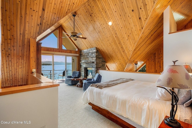 1750 W Valhalla Rd, Coeur Dalene, ID 83814 - carpeted bedroom featuring access to exterior, a water view, wooden walls, high vaulted ceiling, and a stone fireplace