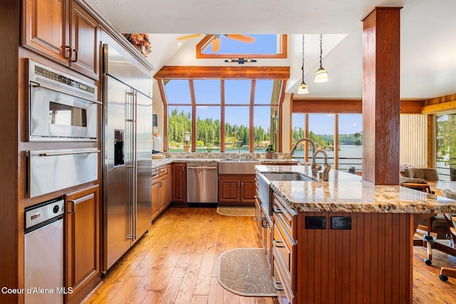 1750 W Valhalla Rd, Coeur Dalene, ID 83814 - kitchen featuring a warming drawer, appliances with stainless steel finishes, light stone countertops, light wood-style flooring, and a ceiling fan
