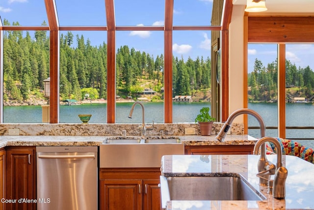 1750 W Valhalla Rd, Coeur Dalene, ID 83814 - kitchen with stainless steel dishwasher, light stone counters, a water view, and brown cabinets