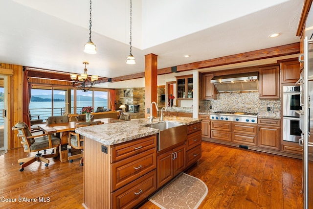 1750 W Valhalla Rd, Coeur Dalene, ID 83814 - kitchen featuring appliances with stainless steel finishes, dark wood-style floors, backsplash, extractor fan, and a chandelier