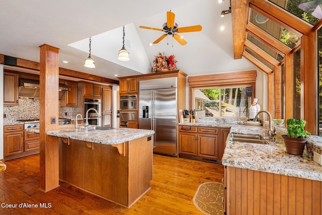 1750 W Valhalla Rd, Coeur Dalene, ID 83814 - kitchen with appliances with stainless steel finishes, a warming drawer, light stone countertops, vaulted ceiling, and backsplash