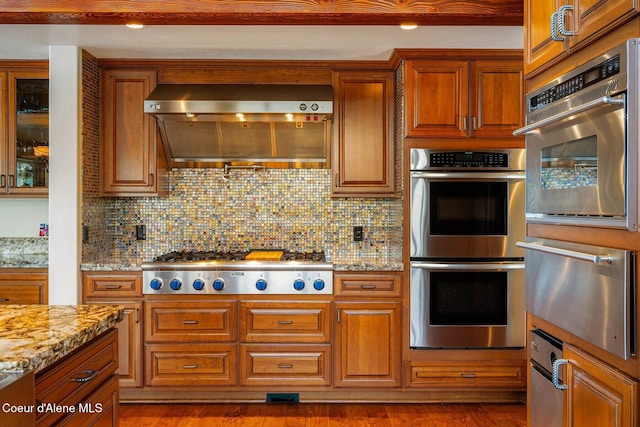 1750 W Valhalla Rd, Coeur Dalene, ID 83814 - kitchen featuring appliances with stainless steel finishes, a warming drawer, wall chimney range hood, and brown cabinets
