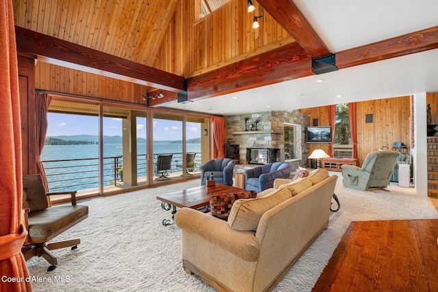1750 W Valhalla Rd, Coeur Dalene, ID 83814 - living area featuring a stone fireplace, healthy amount of natural light, wooden walls, a towering ceiling, and beamed ceiling