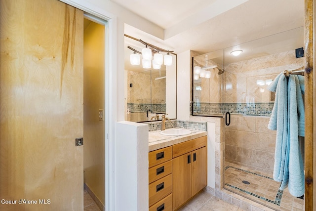 1750 W Valhalla Rd, Coeur Dalene, ID 83814 - bathroom with a stall shower, vanity, tile patterned floors, and tasteful backsplash