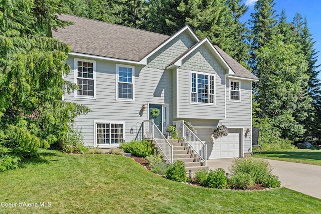 187 White Way, Priest River, ID 83856 - bi-level home featuring concrete driveway, a garage, a shingled roof, and a front lawn