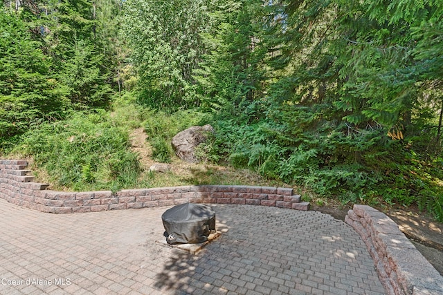 187 White Way, Priest River, ID 83856 - view of patio / terrace featuring an outdoor fire pit and a view of trees