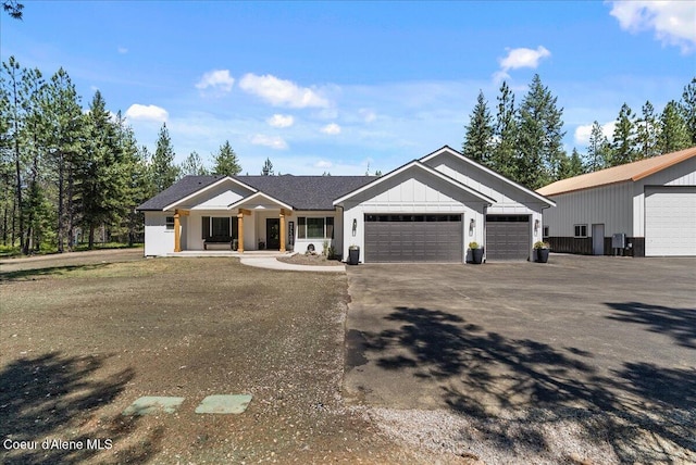 388 Wyatt Ln, Spirit Lake, ID 83869 - view of front of property featuring an attached garage, covered porch, asphalt driveway, and board and batten siding