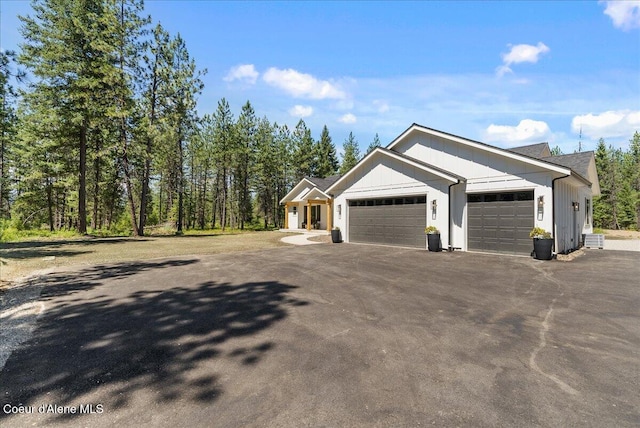 388 Wyatt Ln, Spirit Lake, ID 83869 - view of home's exterior featuring an attached garage, asphalt driveway, and board and batten siding