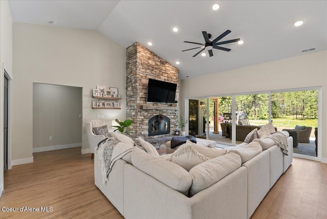 388 Wyatt Ln, Spirit Lake, ID 83869 - living room with high vaulted ceiling, a ceiling fan, light wood-style flooring, a stone fireplace, and recessed lighting