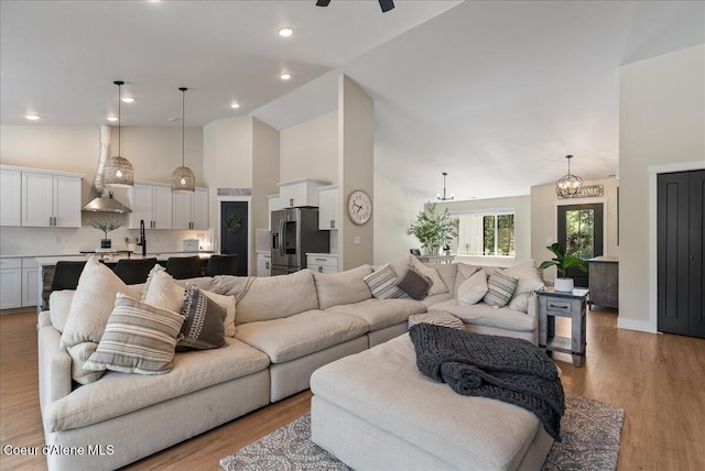 388 Wyatt Ln, Spirit Lake, ID 83869 - living area with high vaulted ceiling, light wood-type flooring, a chandelier, and ceiling fan