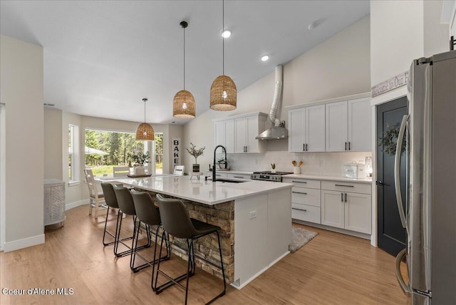 388 Wyatt Ln, Spirit Lake, ID 83869 - kitchen featuring appliances with stainless steel finishes, light wood-style flooring, decorative backsplash, light countertops, and a kitchen breakfast bar