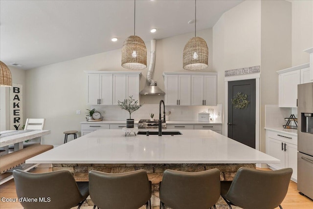 388 Wyatt Ln, Spirit Lake, ID 83869 - kitchen featuring stainless steel fridge, decorative backsplash, a breakfast bar area, high vaulted ceiling, and light countertops