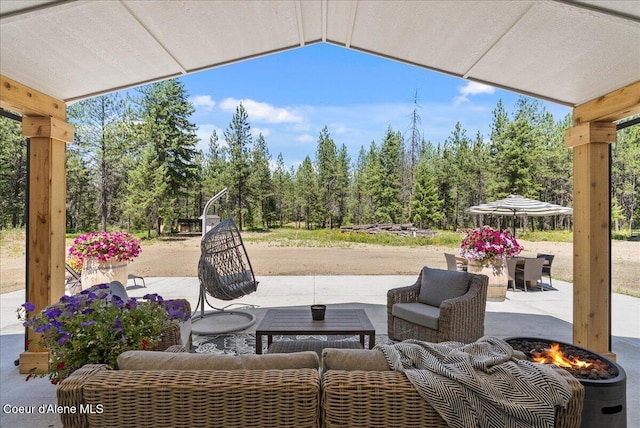 388 Wyatt Ln, Spirit Lake, ID 83869 - view of patio featuring an outdoor living space with a fire pit and view of scattered trees