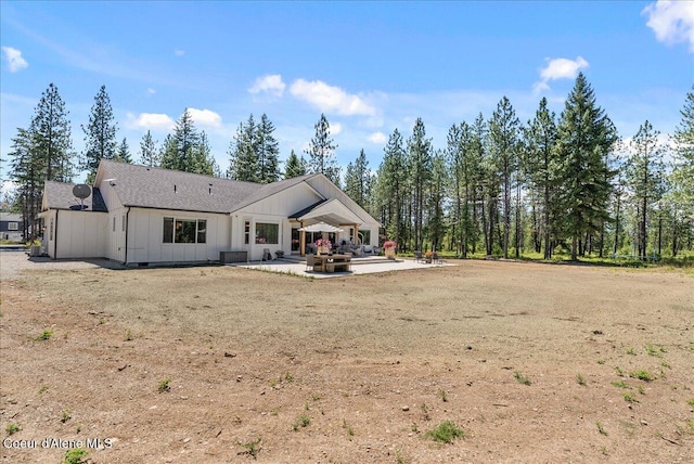 388 Wyatt Ln, Spirit Lake, ID 83869 - back of property with board and batten siding and a patio area