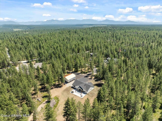 388 Wyatt Ln, Spirit Lake, ID 83869 - drone / aerial view of a heavily wooded area and a mountain backdrop
