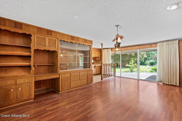 9603 N Strahorn Rd, Hayden Lake, ID 83835 - unfurnished living room featuring a textured ceiling, dark wood-style flooring, and built in desk