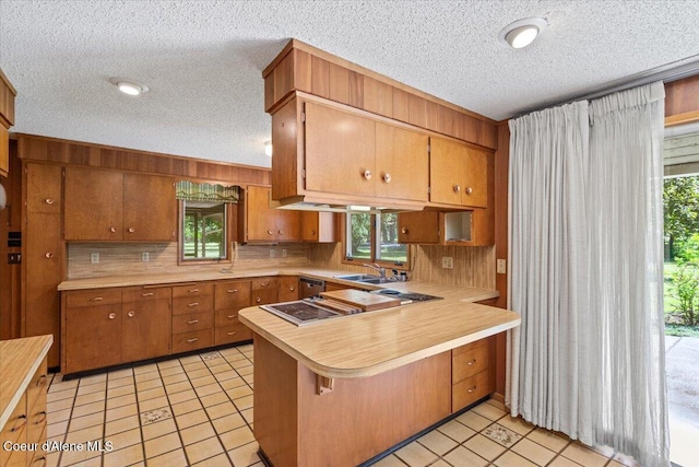 9603 N Strahorn Rd, Hayden Lake, ID 83835 - kitchen with stovetop with downdraft, light countertops, a textured ceiling, a peninsula, and light tile patterned floors