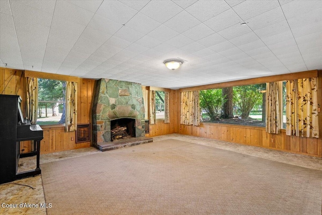 9603 N Strahorn Rd, Hayden Lake, ID 83835 - unfurnished living room with wood walls, carpet flooring, and a stone fireplace
