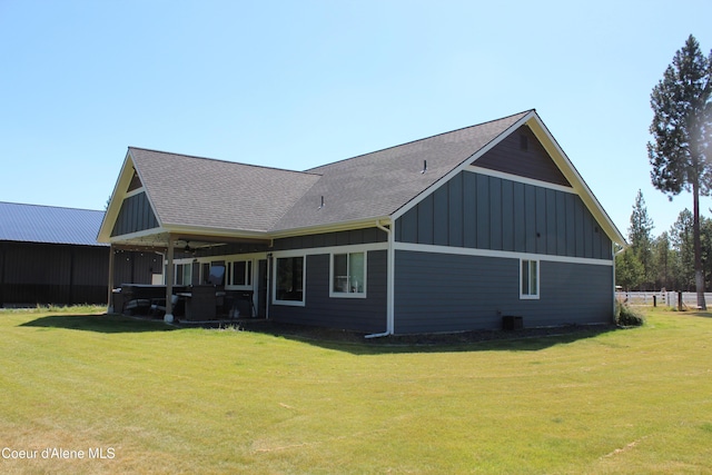 23426 N Massif Rd, Rathdrum, ID 83858 - back of house with board and batten siding, a lawn, and a shingled roof