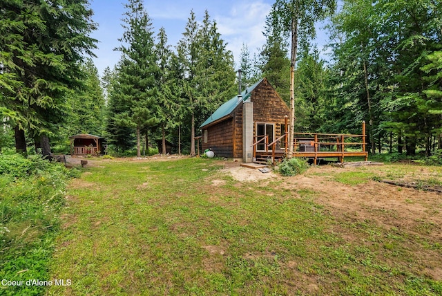 1053 Upper Pack River Rd, Sandpoint, ID 83864 - view of yard featuring a wooden deck, an outbuilding, and a view of trees