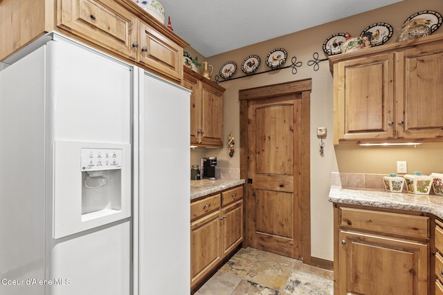 11477 N Rocking R Rd, Hayden, ID 83835 - kitchen with white refrigerator with ice dispenser, light stone countertops, light stone finish floors, and brown cabinets