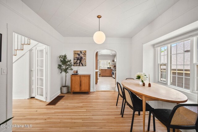 114 E Foster Ave, Coeur Dalene, ID 83814 - dining space featuring arched walkways, light wood finished floors, and stairway