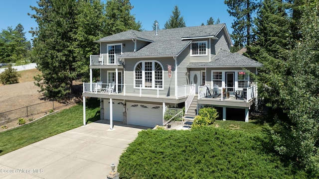 5570 E Shoreline Dr, Post Falls, ID 83854 - view of front of home with a balcony, a garage, driveway, roof with shingles, and stairway